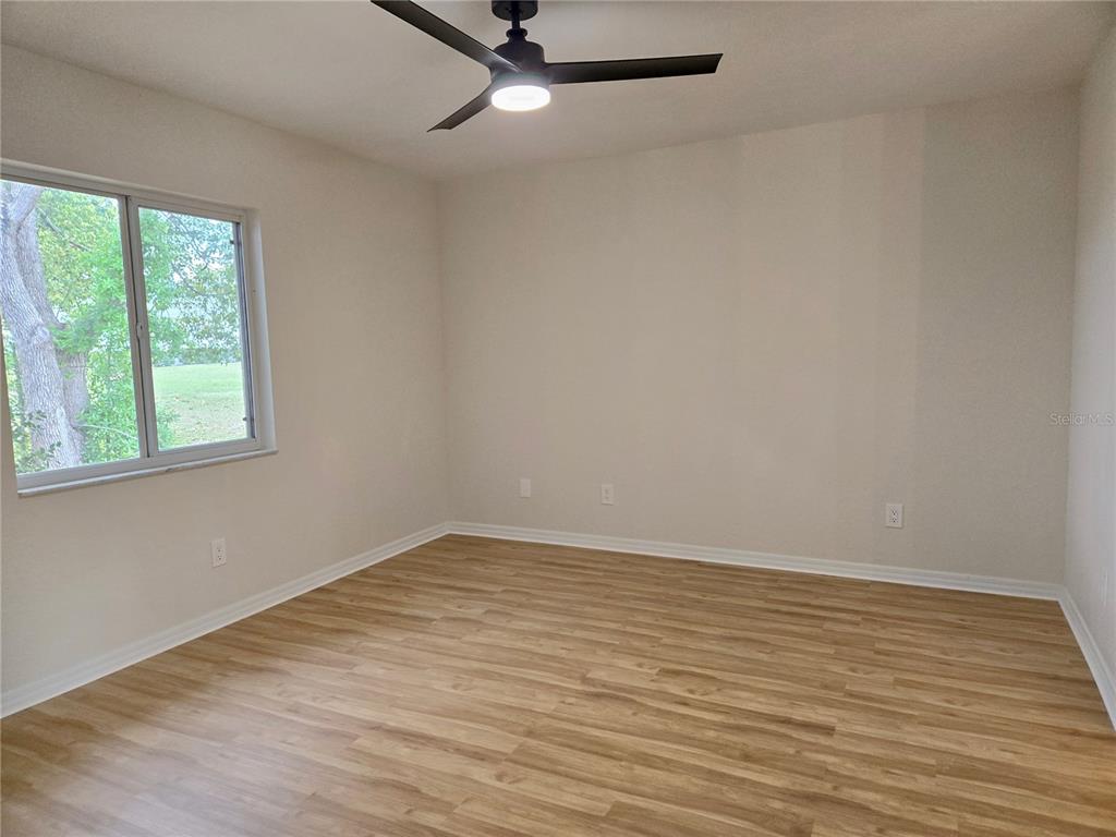 6121 Southwest 103rd Loop Ocala, FL 34476 - Photo 27 of 32 wooden floor in an empty room with a window