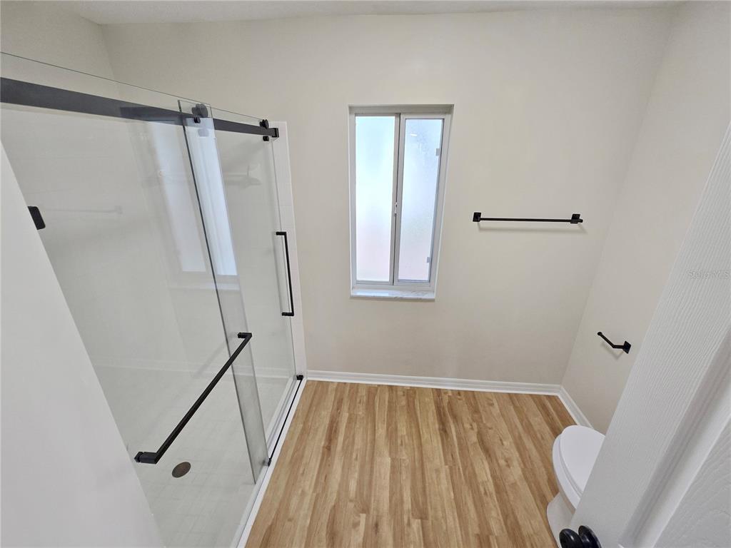 6121 Southwest 103rd Loop Ocala, FL 34476 - Photo 29 of 32 a view of a room with wooden floor and white walls