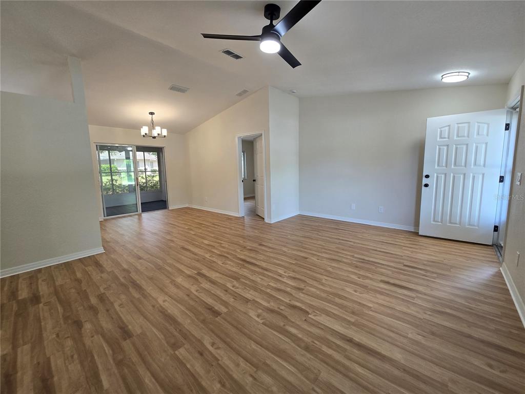 6121 Southwest 103rd Loop Ocala, FL 34476 - Photo 7 of 32 a view of an empty room with wooden floor and a window