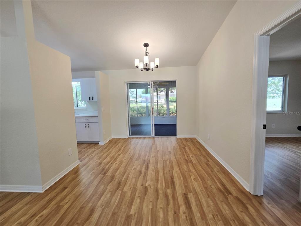 6121 Southwest 103rd Loop Ocala, FL 34476 - Photo 9 of 32 wooden floor in an empty room with a window