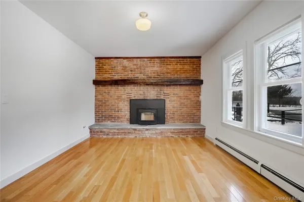 a view of empty room with wooden floor and fireplace
