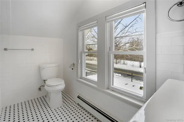 a bathroom with a toilet a window and a shower