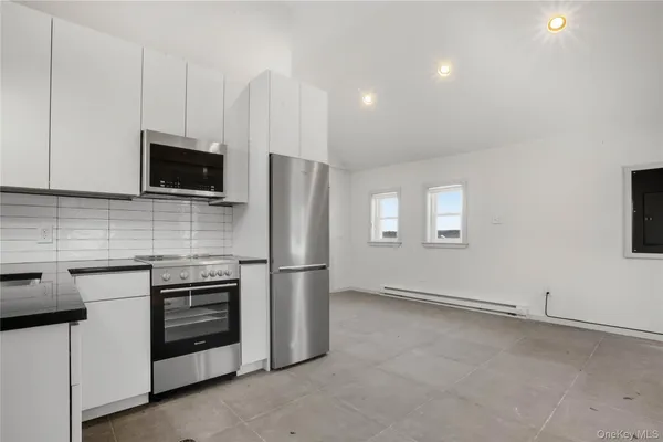 a kitchen with stainless steel appliances a stove microwave and refrigerator