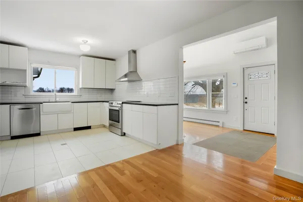 a kitchen with stainless steel appliances granite countertop a refrigerator sink and white cabinets