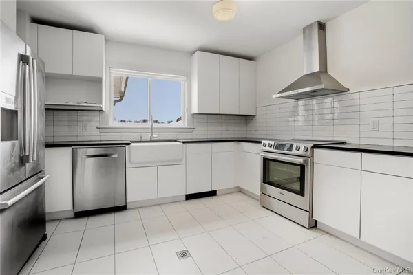 a kitchen with white cabinets stainless steel appliances and sink