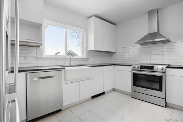 a kitchen with white cabinets stainless steel appliances and sink
