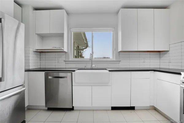 a kitchen with white cabinets and a refrigerator