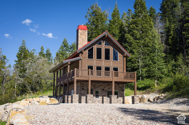 917 West Deep Forest Road Coalville, UT 84017 - Photo 41 of 41 Log cabin exterior with an elevated deck, stone chimney, and gable windows