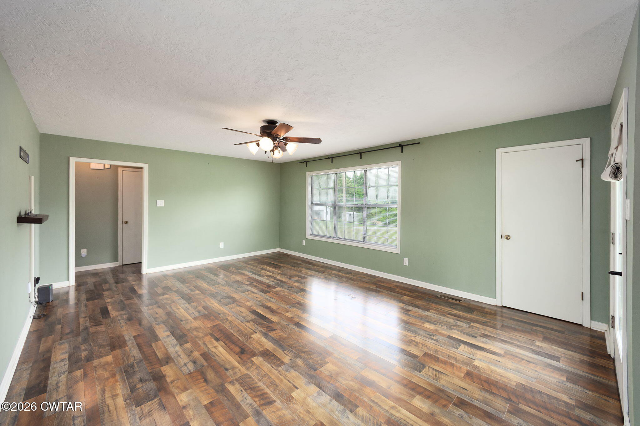 306 Jim Jackson Road Humboldt, TN 38343 - Photo 5 of 29 a view of empty room with wooden floor and fan