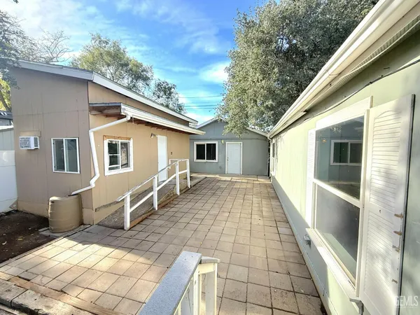 a front view of house with yard outdoor seating and covered with trees