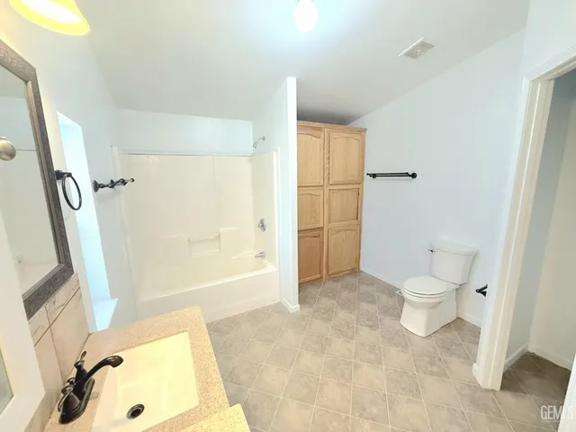 a bathroom with a tub shower and toilet