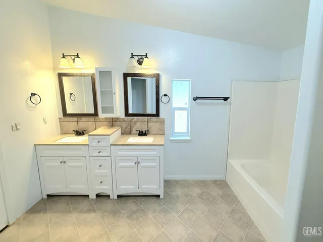 a bathroom with a tub sink and mirror