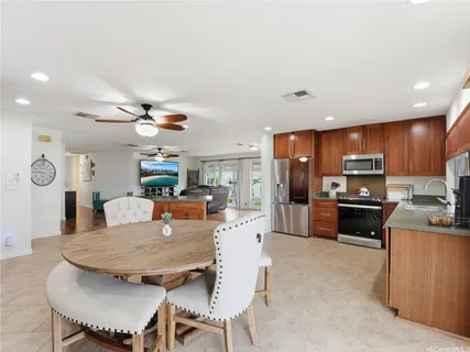 a kitchen with kitchen island a dining table and chairs