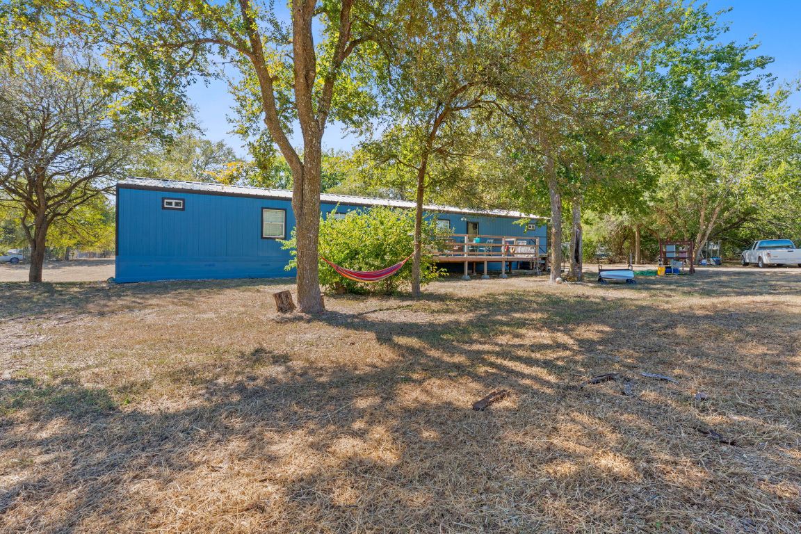 a view of a house with a large tree and wooden fence