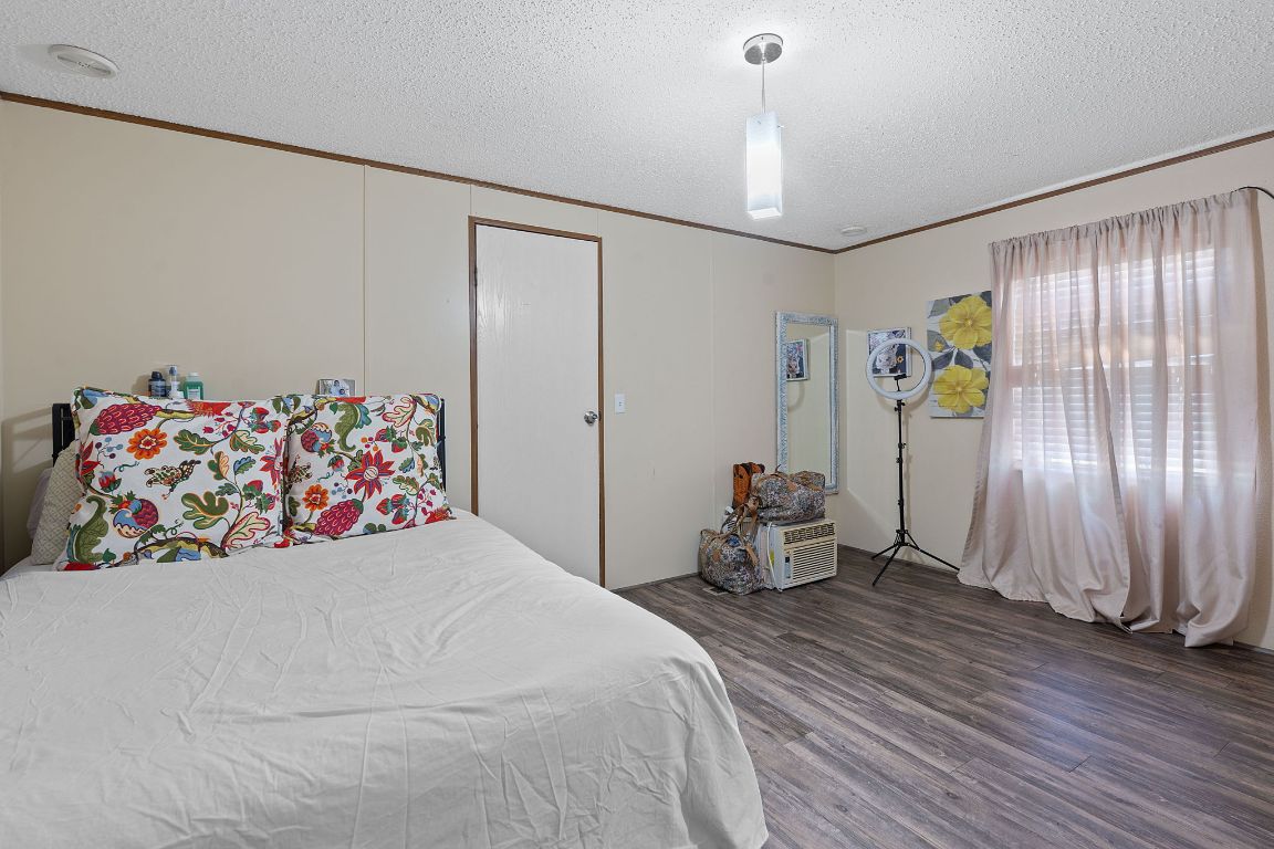 155 Forister Ranch Drive Dale, TX 78616 - Photo 17 of 30 a bedroom with a bed and a chandelier