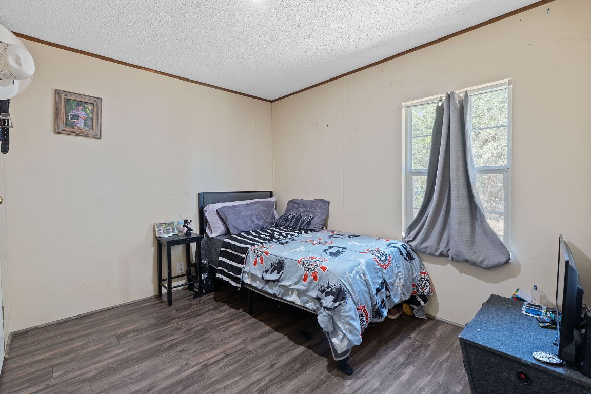 155 Forister Ranch Drive Dale, TX 78616 - Photo 18 of 30 a bedroom with a bed and a flat tv screen on a dresser