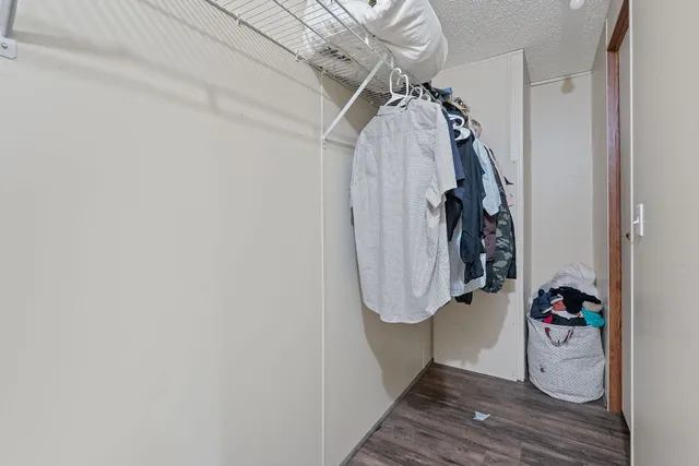 a view of walk in closet with clothes and shoes