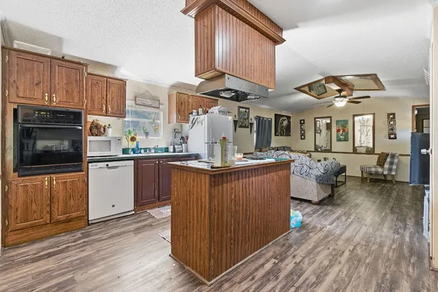a kitchen with stainless steel appliances granite countertop a stove a sink dishwasher and a microwave oven with cabinets