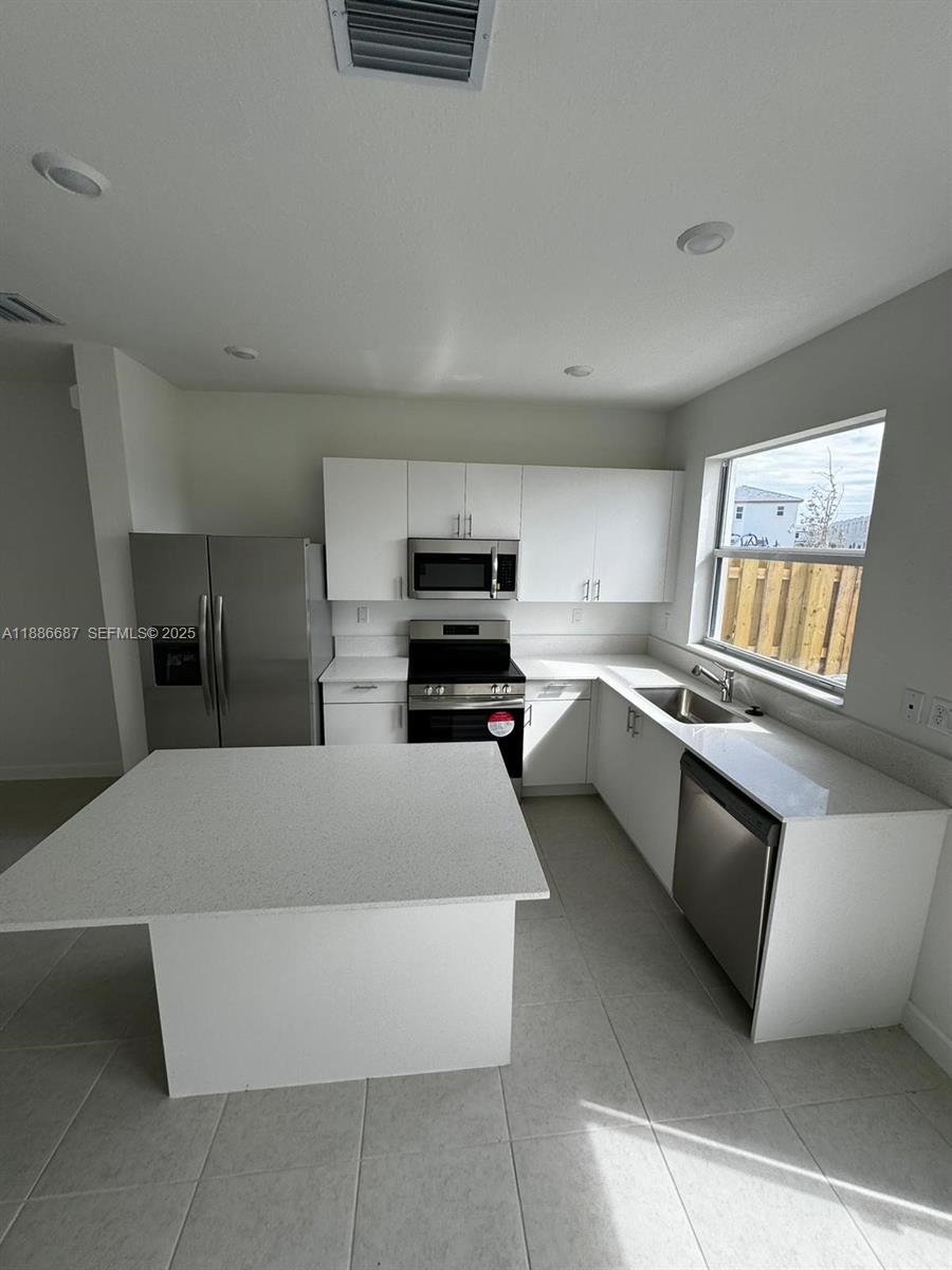 16270 Southwest 292nd Street Homestead, FL 33033 - Photo 5 of 29 a kitchen with stainless steel appliances a refrigerator sink and stove
