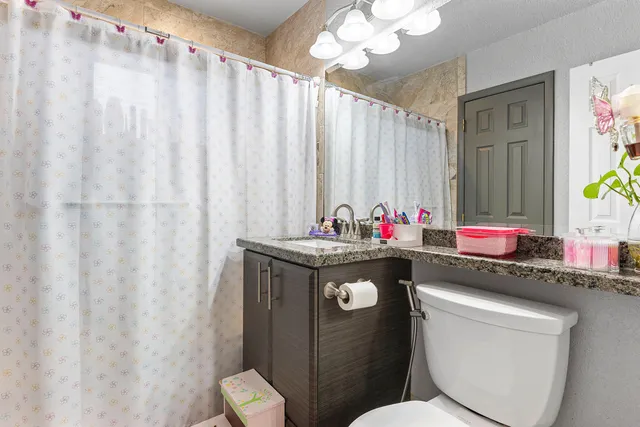 a bathroom with a granite countertop sink and a mirror