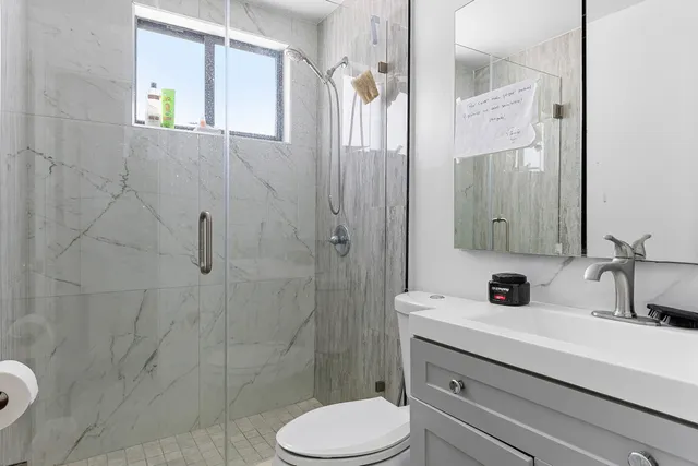 a bathroom with a sink a toilet and shower