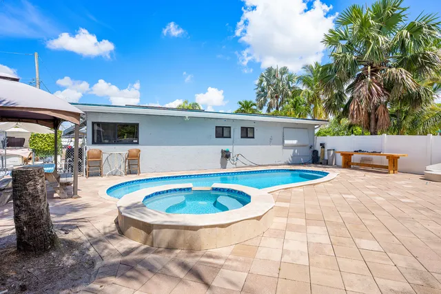 a front view of house with yard swimming pool and furniture