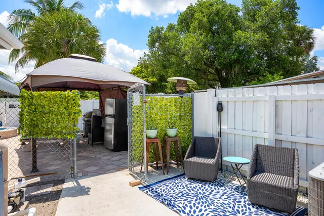 a view of a patio with couches table and chairs and potted plants