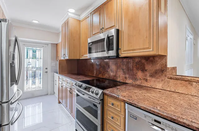 a kitchen with granite countertop a stove and cabinets