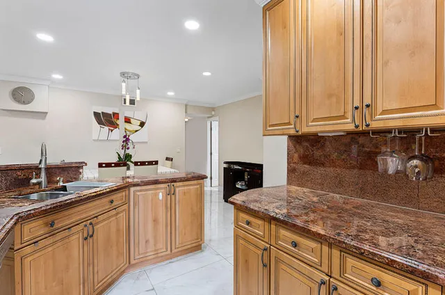 a kitchen with kitchen island granite countertop a sink stainless steel appliances and cabinets