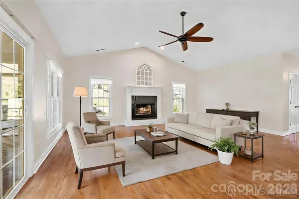 a living room with furniture a ceiling fan and a fireplace