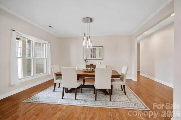 a dining room with wooden floor and a rug
