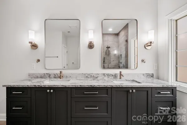 a bathroom with a granite countertop double vanity sink and a mirror