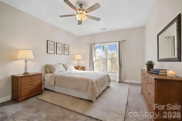 a bedroom with a bed chandelier and a window