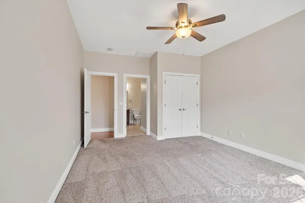wooden floor in an empty room with a chandelier fan