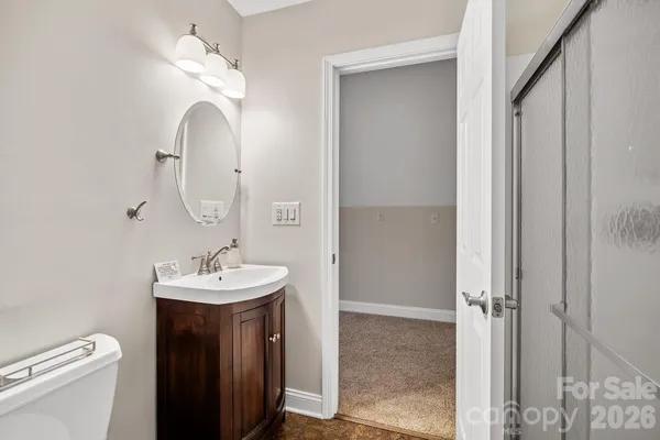 a bathroom with a sink a toilet and a mirror