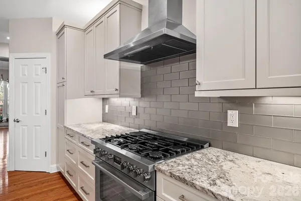 a kitchen with granite countertop a stove and a cabinets