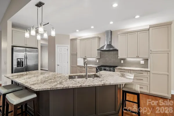a kitchen with kitchen island granite countertop a center island a stove cabinets a dining table and chairs