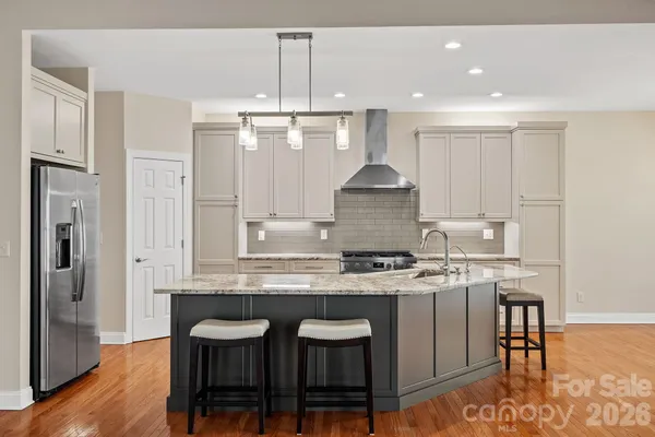 a kitchen with kitchen island granite countertop a sink stove and refrigerator