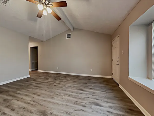 a view of an empty room with wooden floor