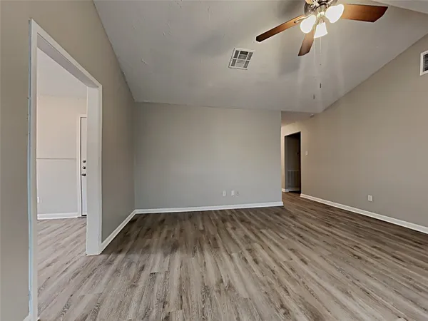 a view of an empty room with wooden floor