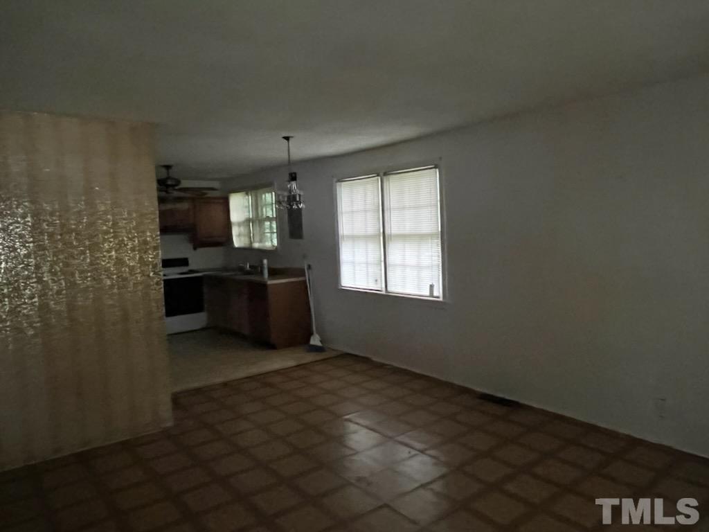 6016 Colonial Drive Raleigh, NC 27603 - Photo 4 of 10 an empty room with a kitchen and windows