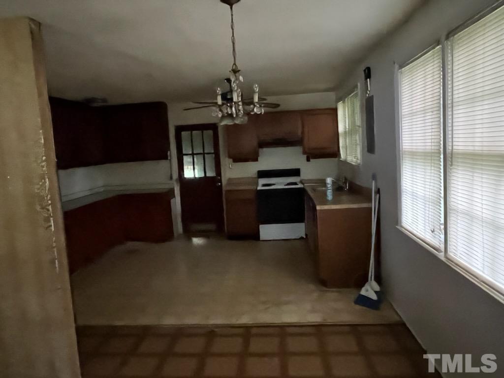 6016 Colonial Drive Raleigh, NC 27603 - Photo 6 of 10 a kitchen with stainless steel appliances granite countertop a refrigerator a oven a sink with a dining table and chairs