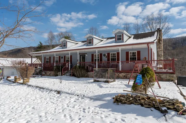 a view of a house with a yard covered in snow