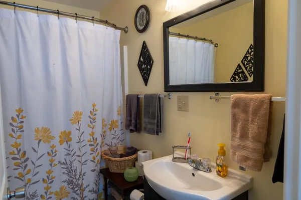 a bathroom with a sink and mirror with bathtub
