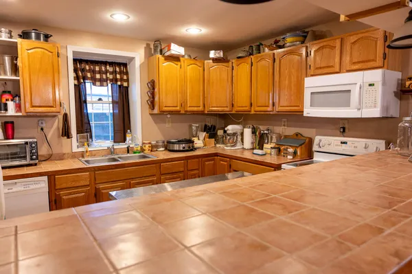 a large kitchen with stainless steel appliances a sink and cabinets