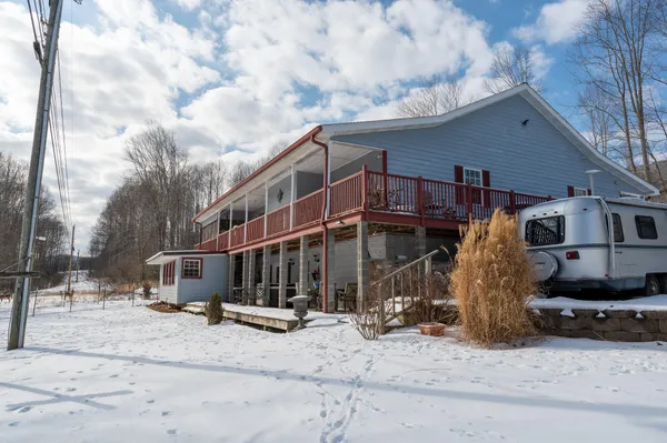 a view of a house with snow on the side of road