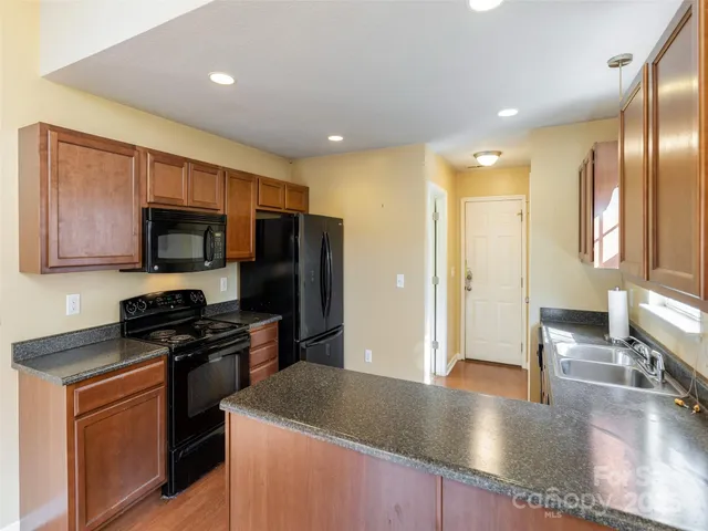 a kitchen with stainless steel appliances granite countertop a stove a sink and a refrigerator