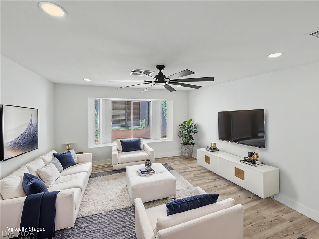 8977 Paige Rene Court Las Vegas, NV 89117 - Photo 19 of 31 Well-lit living area featuring rich flooring, abundant natural light, and modern recessed lighting.
