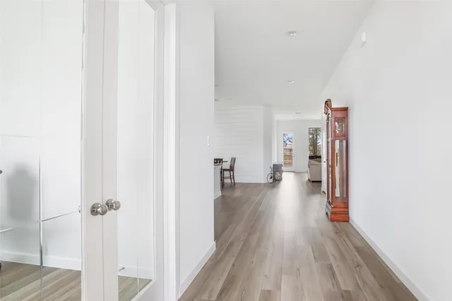 a view of a hallway with wooden floor and closet