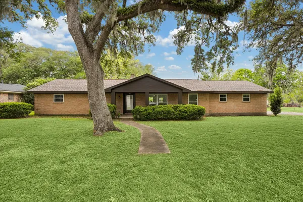 a front view of a house with a yard and trees